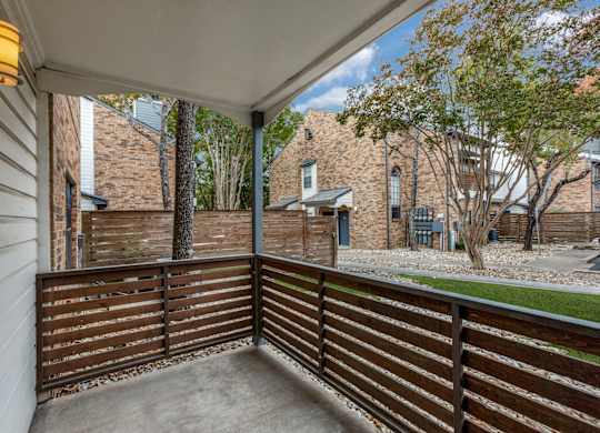 A balcony with a wooden railing and a concrete floor.