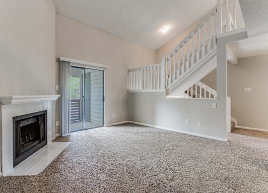 a living room with a fireplace and a staircase
