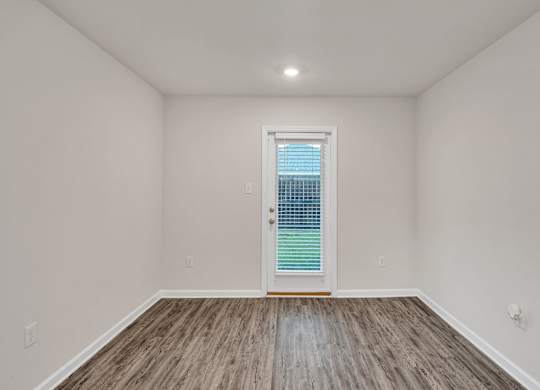 A room with a window and wooden flooring.