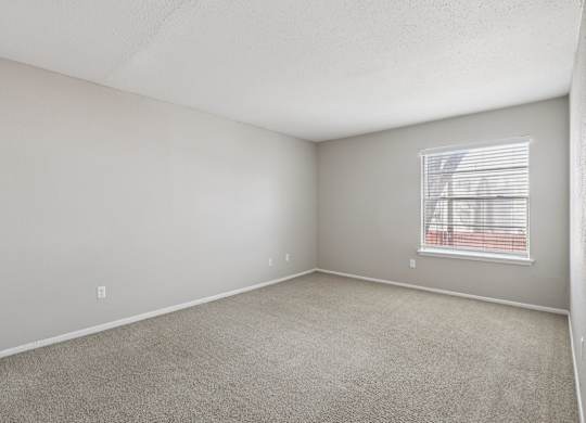 A room with a window covered by blinds.