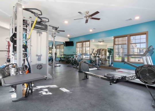 a home gym with weights and a ceiling fan