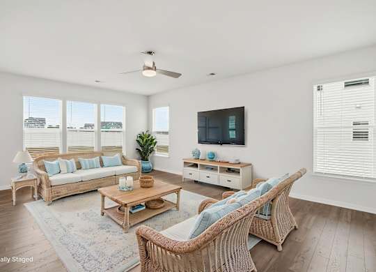 A living room with a white ceiling and a television on the wall.