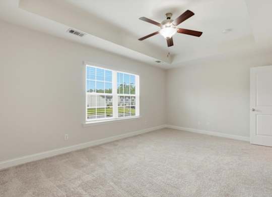 A room with a ceiling fan and a window with blinds.