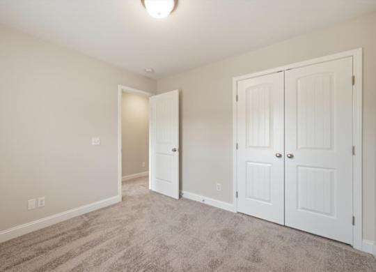 A room with two white doors and a carpeted floor.