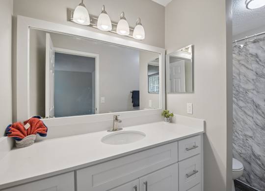 A bathroom with a marble wall and a white sink.