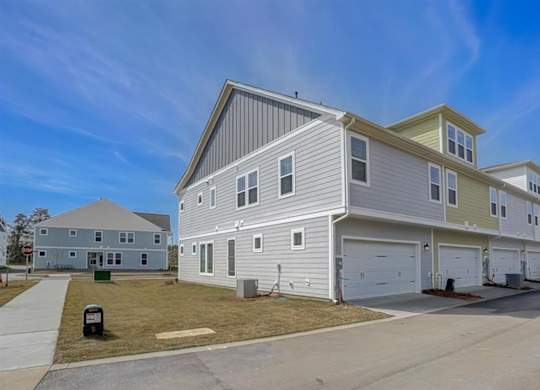 A row of houses with garages and a clear blue sky.