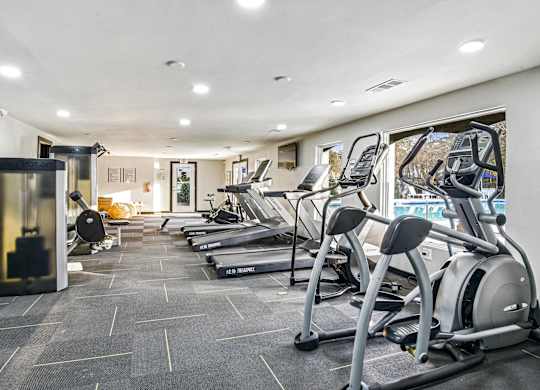 A gym with treadmills and elliptical machines.