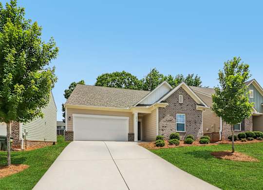 A residential house with a driveway in front.