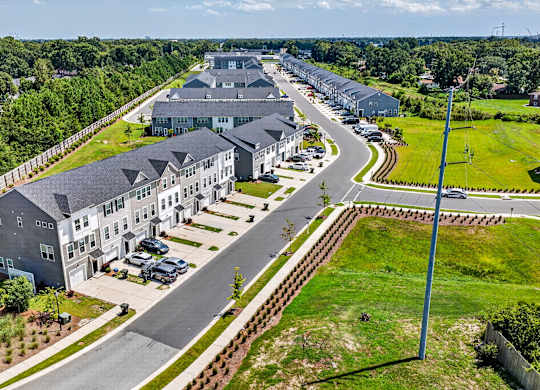 A large, modern building complex with a parking lot in front.
