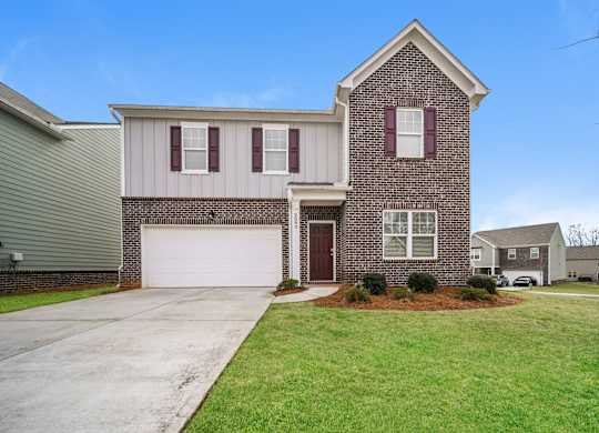 A house with a red door and a garage.