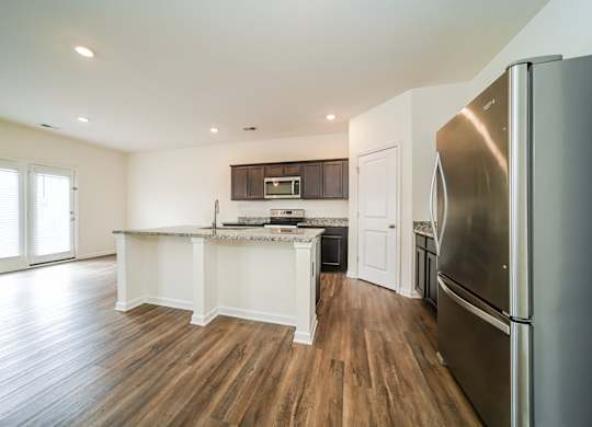 A kitchen with a refrigerator on the right side.