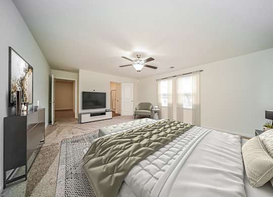 A bedroom with a large bed and a flat screen TV.