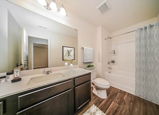 A bathroom with a white shower curtain and a white toilet.