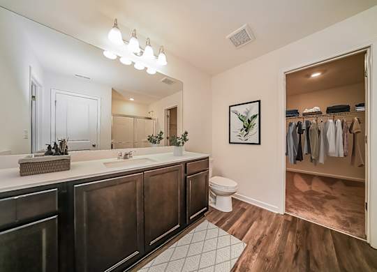 A bathroom with a toilet, sink, and a mirror.