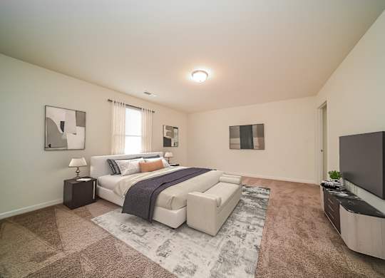 A bedroom with a large bed and a flat screen TV mounted on the wall.