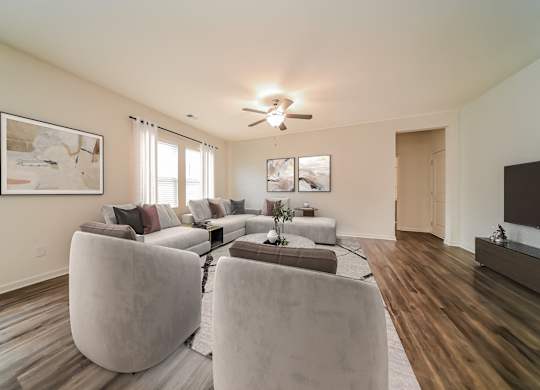 A living room with a large couch and a ceiling fan.