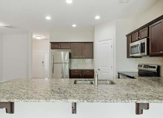 A kitchen with granite countertops and stainless steel appliances.