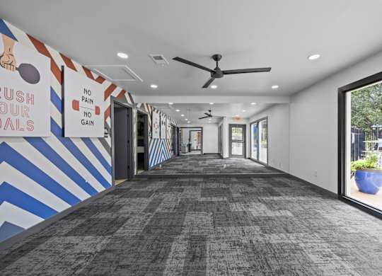 A hallway with a blue and white striped wall and a sign that says "rush to our goals".