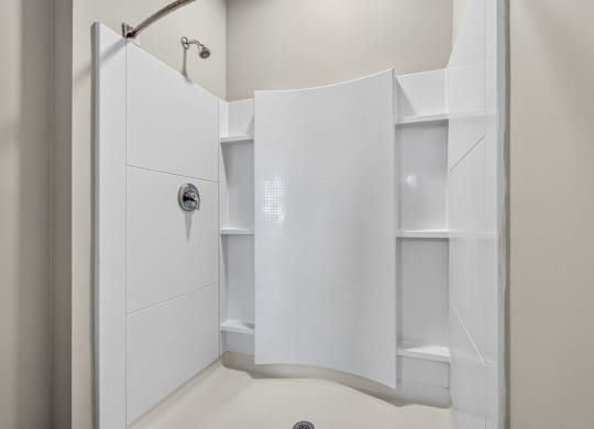 A white bathroom with a walk in shower.