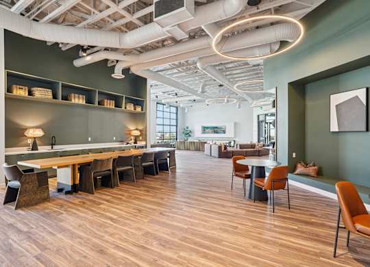 A room with wooden floors and a long table with chairs.