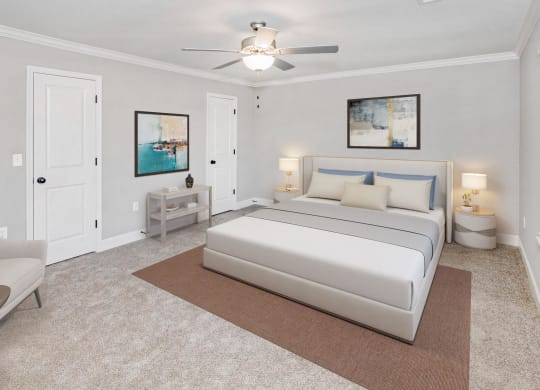 a bedroom with a white bed and a ceiling fan