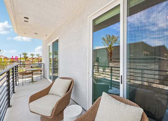 A patio with two chairs and a table.