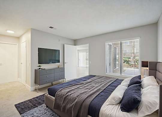 A bedroom with a large bed and a flat screen TV.