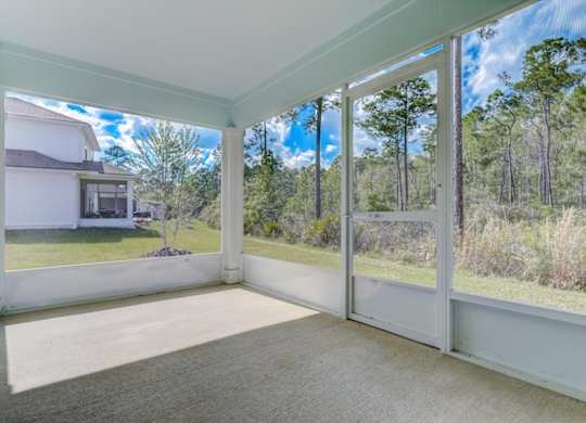 Screened porch overlooking a wooded backyard.
