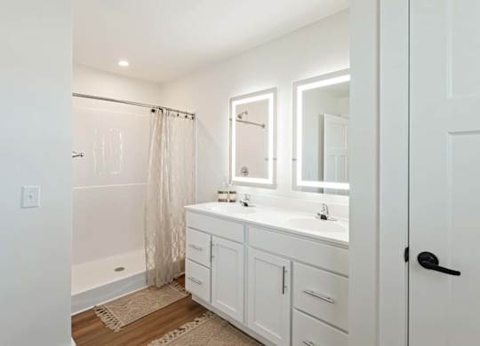 A white bathroom with a tub, sink, and mirror.