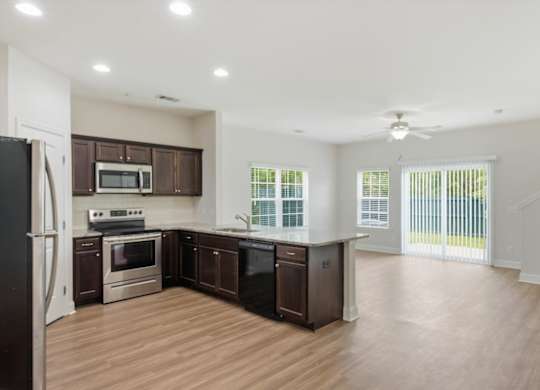 A kitchen with dark wood cabinets and stainless steel appliances.