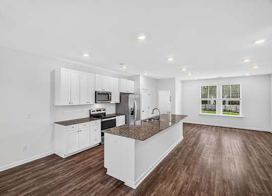A modern kitchen with white cabinets and a central island.