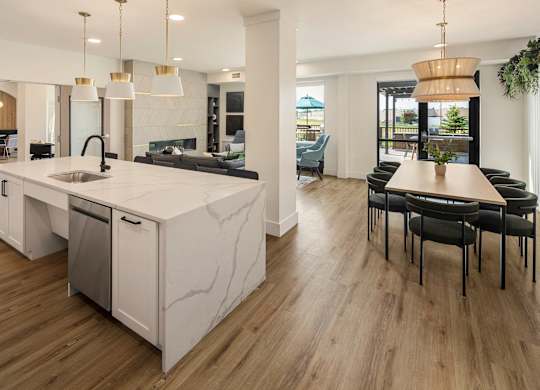 A modern kitchen with a marble island and wooden floors.