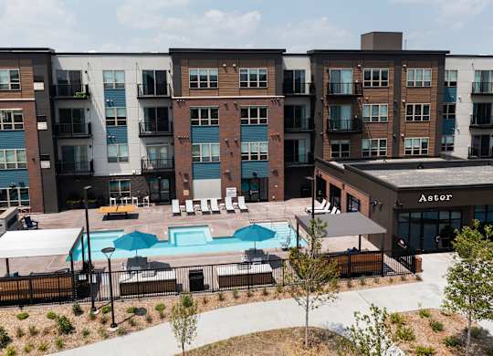 A large apartment complex with a pool in the middle.
