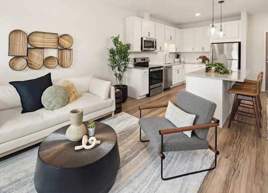 A modern living room with a white sofa, grey armchair, and a wooden coffee table.