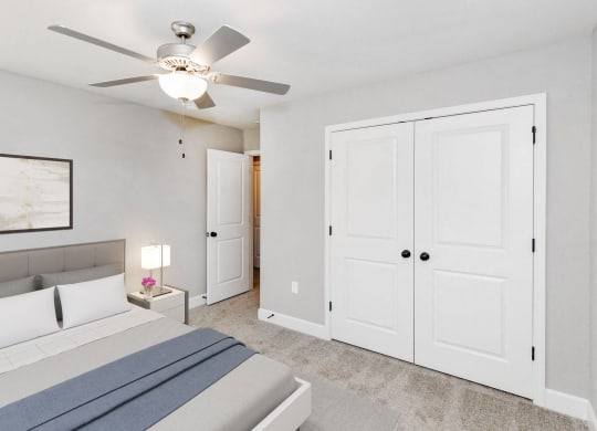 a bedroom with a bed and a ceiling fan