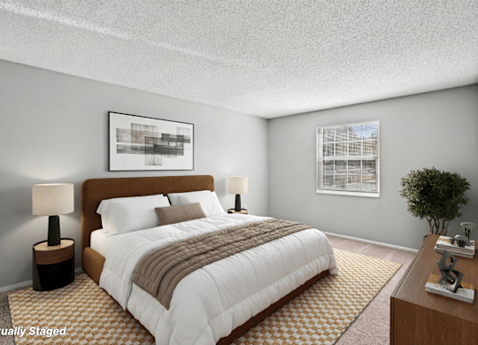 A bedroom with a large bed, a lamp, and a framed picture on the wall.