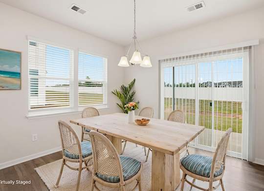 A dining room with a wooden table and chairs.