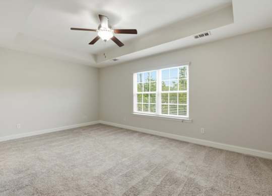 A room with a ceiling fan and a window with blinds.