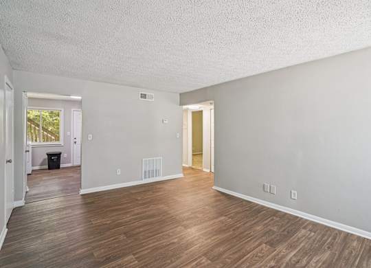 A room with wooden flooring and white walls.