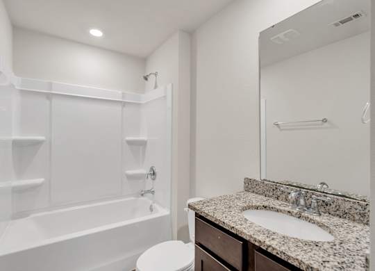 A white bathroom with a sink, toilet, and bathtub.