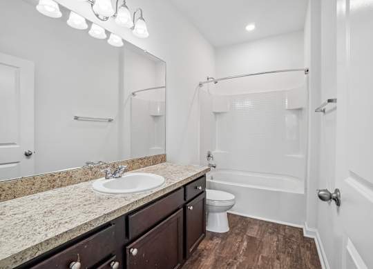 A bathroom with a sink, toilet, and bathtub.