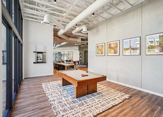 A room with a long table and three pictures on the wall.