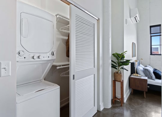 a small laundry room with a washer and dryer and a closet