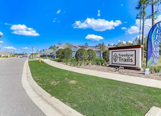 Entrance to Treeline Trails neighborhood with sign and Welcome flag.