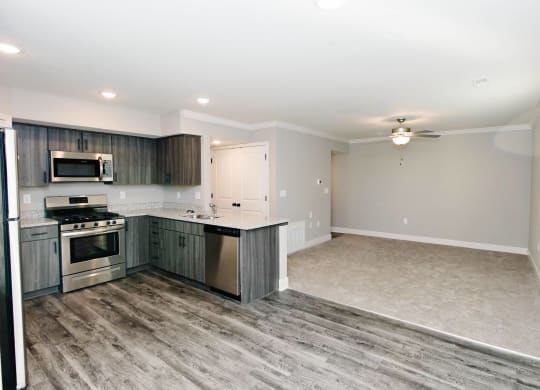 an empty kitchen and living room with wood flooring
