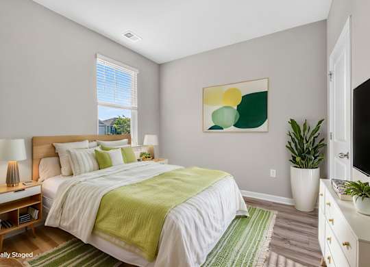 A bedroom with a bed, nightstands, and a painting on the wall.