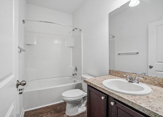 A white bathroom with a toilet, sink, and bathtub.