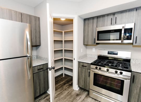 a renovated kitchen with stainless steel appliances and wooden cabinets