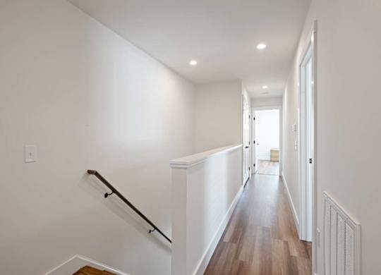 A long hallway with a staircase on the left side.
