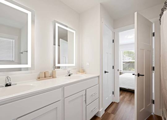 A white bathroom with a large mirror above the sink.